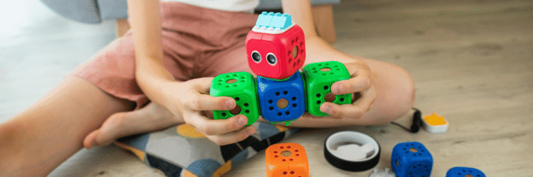 Preschool child playing with colorful STEM building blocks during hands-on activity at home