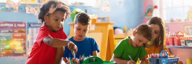 Preschool children working together at an activity table with markers and art supplies