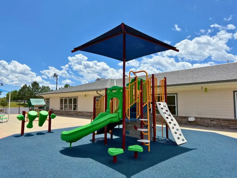 Preschool playground at STEM Child Care in Castle Rock, CO with shaded play structure and slides. Best daycare near me!
